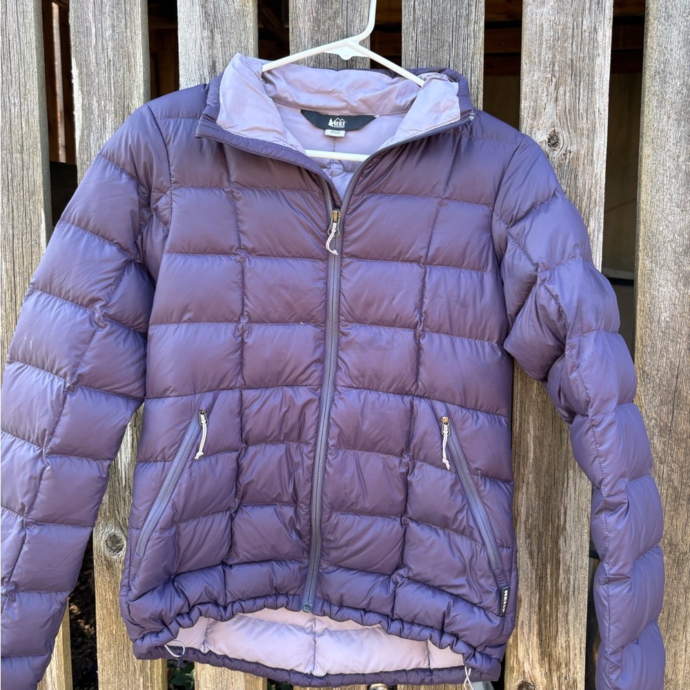 Purple puffer jacket with adjustable waist, featuring a hood and multiple pocket